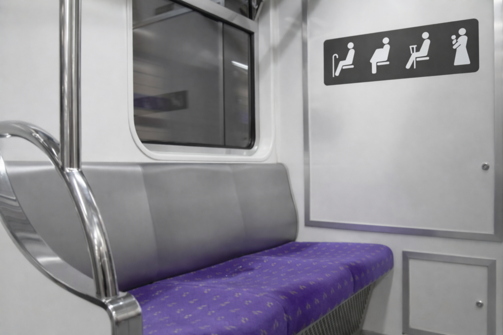 Priority seating area inside a modern Seoul subway train with purple seats and elderly pregnant disabled icon sign